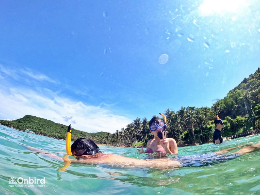 Khue and her boy friend testing mask and praticing floating skill with our guides on the snorkeling trip in Phu Quoc, Vietnam
