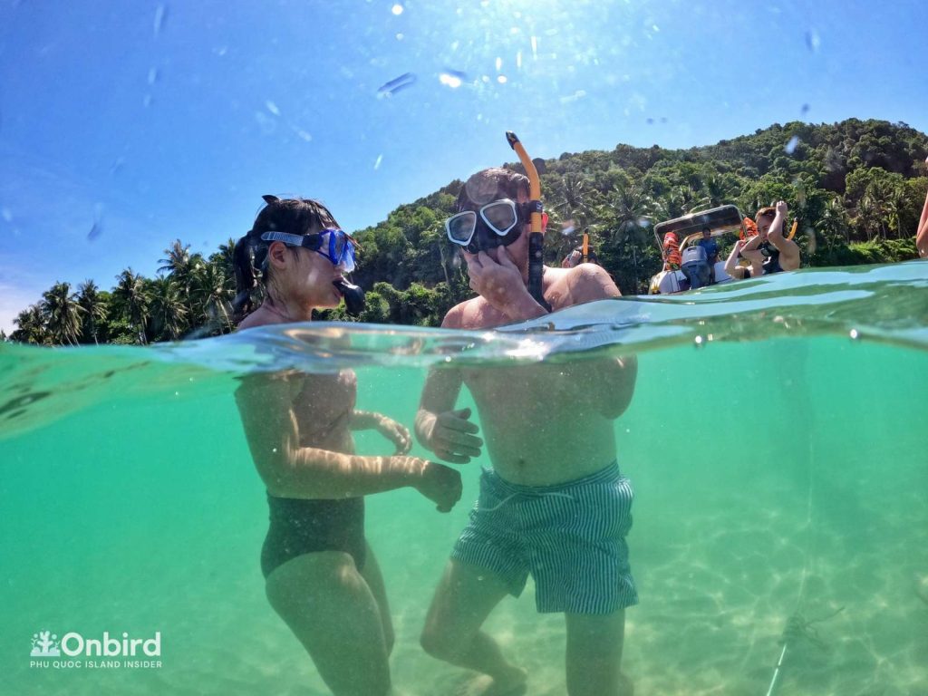 Khue and her boy friend testing mask and praticing floating skill with our guides on the snorkeling trip in Phu Quoc, Vietnam