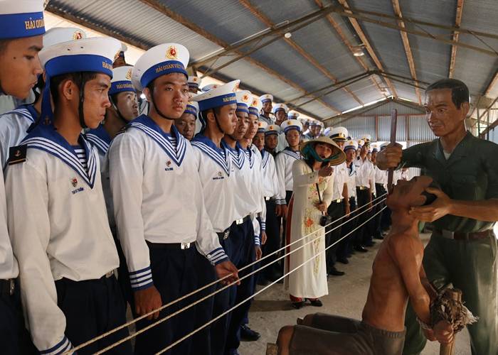 Vietnamese navy officers visiting Phu Quoc Prison, reflecting on the brutal torture once inflicted on prisoners of war.